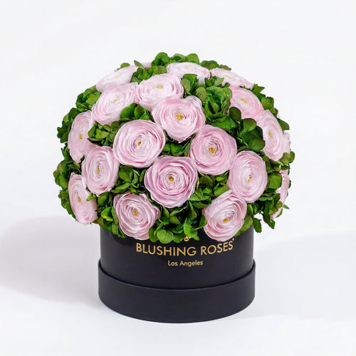 Round black box with pink flowers and green leaves, branded 'Blushing Roses' on a white background