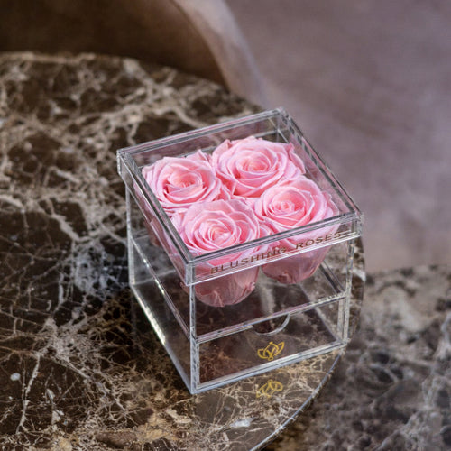     Luxury pink forever roses in acrylic drawer box, preserved rose arrangement for Valentine’s Day, Mother’s Day, and elegant gifts | Blushing Roses Clear cube with pink roses on a marble surface