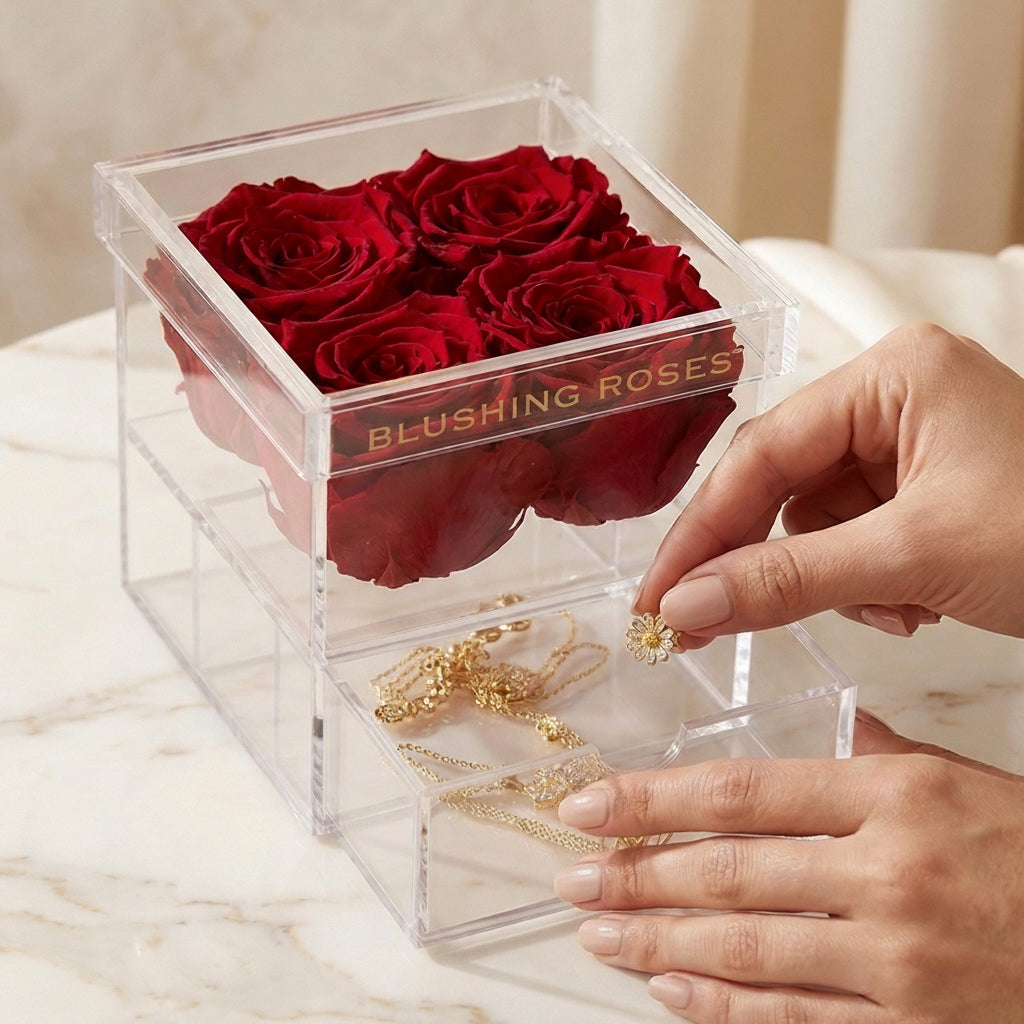 Luxury red forever roses in acrylic display box, preserved rose gift for her, anniversaries, Valentine’s Day, and Mother’s Day | Blushing Roses ,Clear box with red roses and jewelry, featuring 'blushing Roses' brand.
