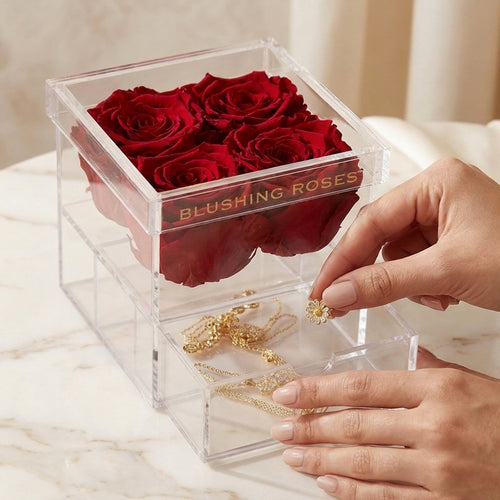 Luxury red forever roses in acrylic display box, preserved rose gift for her, anniversaries, Valentine’s Day, and Mother’s Day | Blushing Roses ,Clear box with red roses and jewelry, featuring 'blushing Roses' brand.