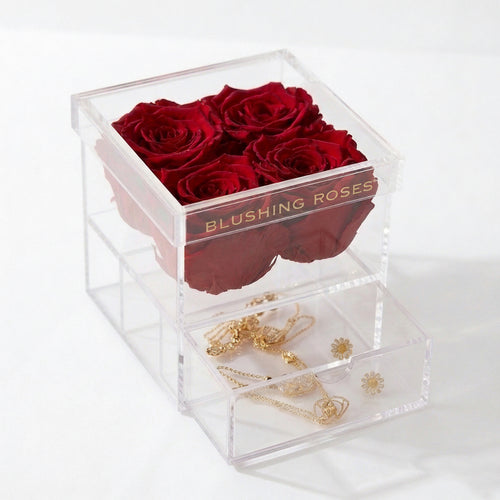 Luxury red preserved roses in clear acrylic drawer box, forever roses gift for anniversaries, birthdays, Valentine’s Day, and home décor | Blushing Roses Clear cube box with red roses and gold jewelry on a white background